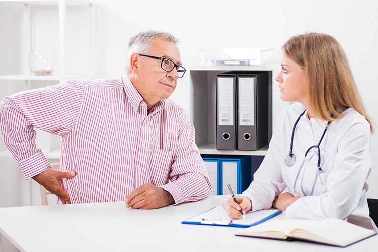 Older man with young doctor discussing pain management options