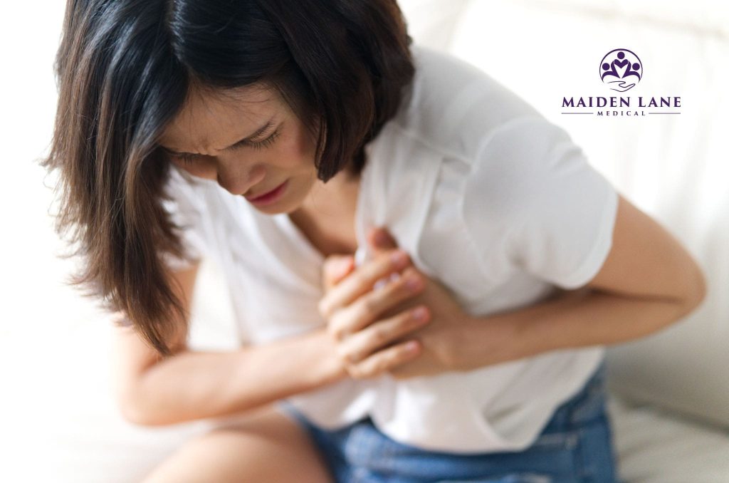 A woman experiencing the signs and symptoms of heart disease.