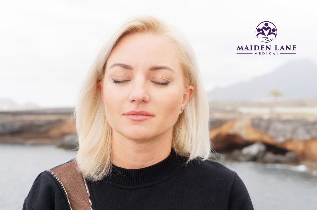 A woman trying Bellows breath exercises outside in NYC.