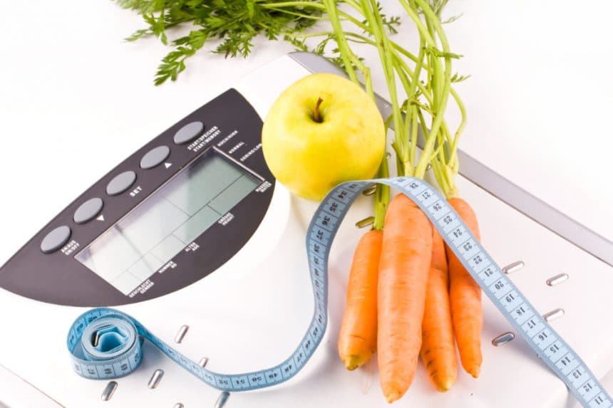 Scale and measuring tape along with an apple and carrots - Weight Loss Nutrition Manhattan New York