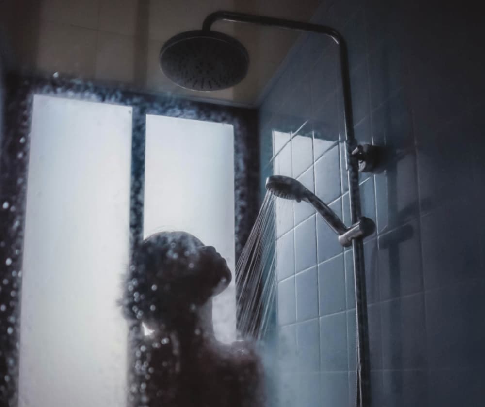 Close up of Woman in shower with steamed glass