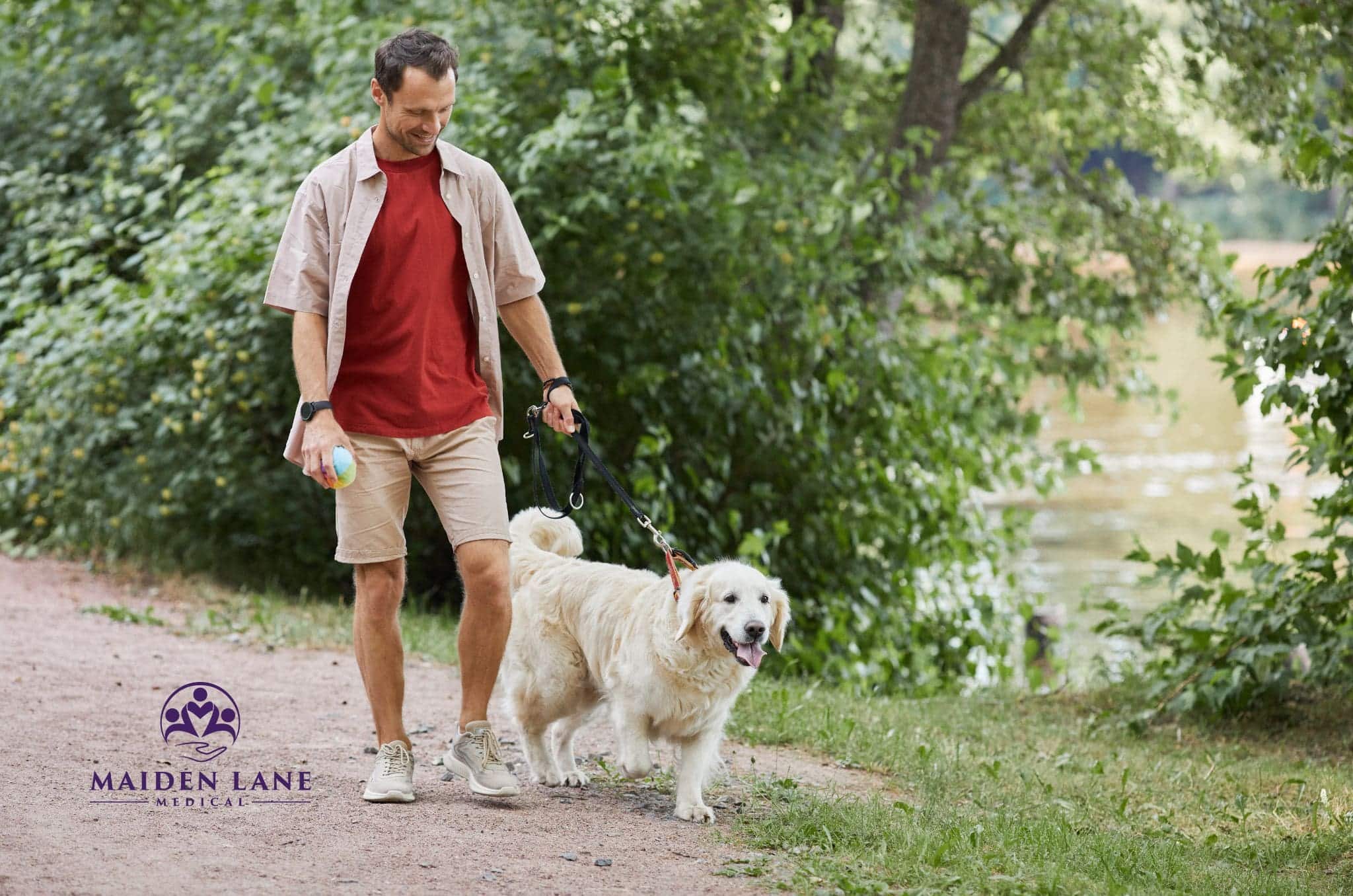 A man walking his dog in NYC while spending time in nature.