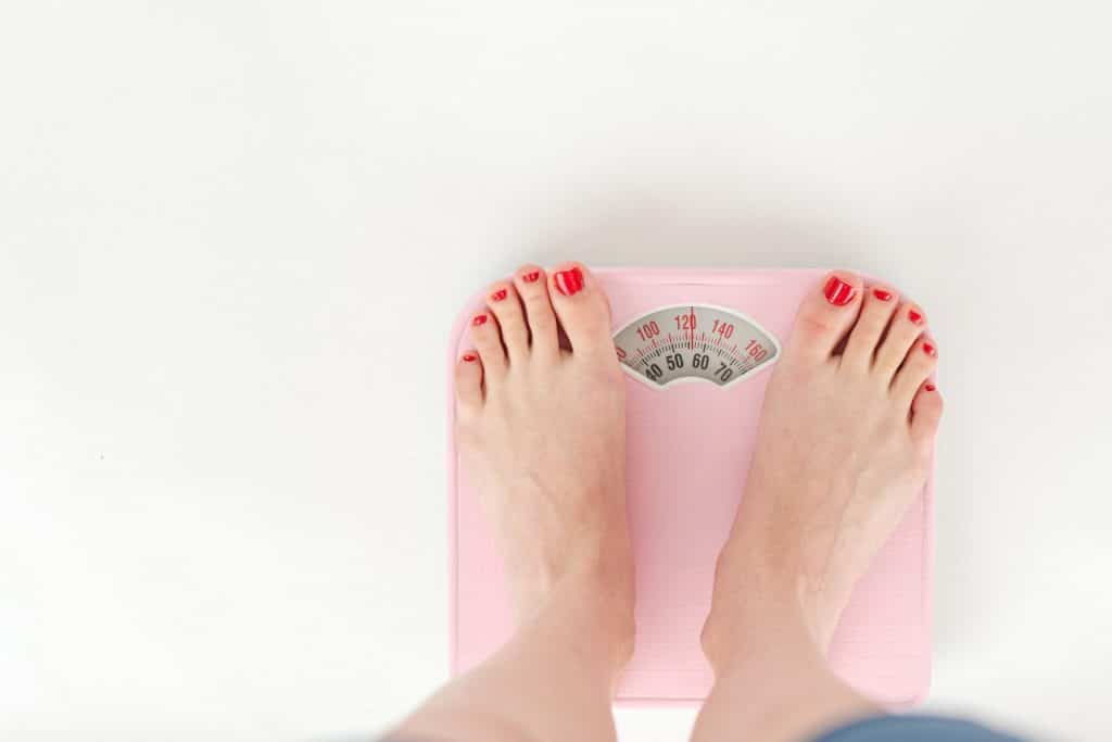 Woman's feet on a pink scale showing weight.- Maiden Lane Medical I New York, NY