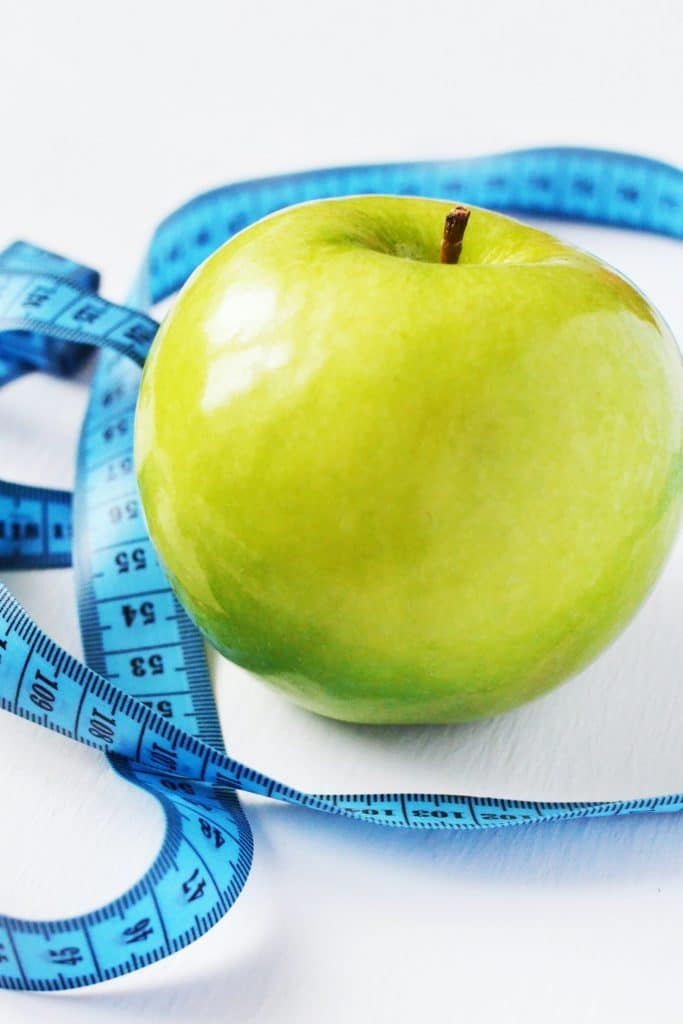 Green apple with measuring tape around it. - Maiden Lane Medical I New York, NY