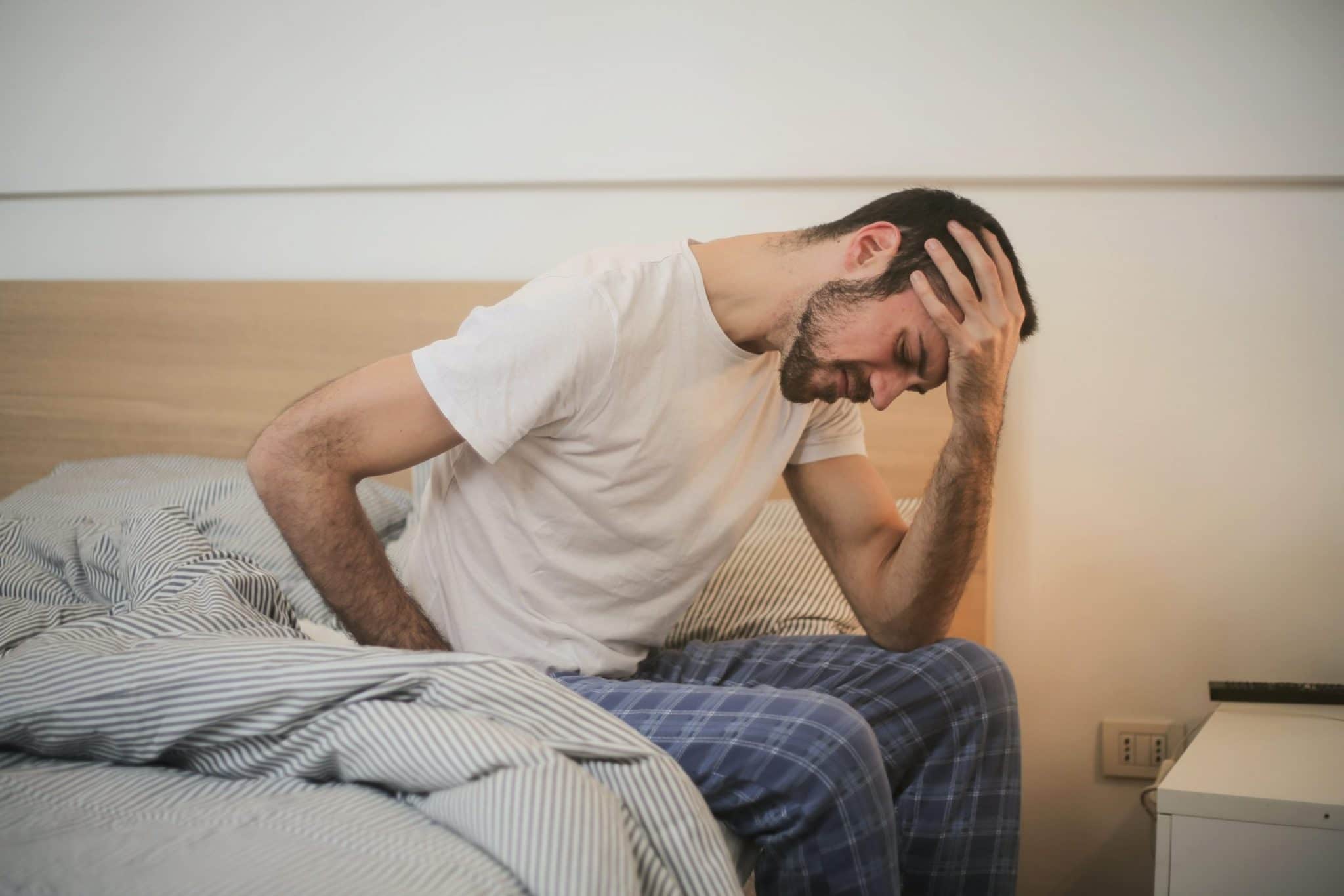 man in pain in bed after waking up