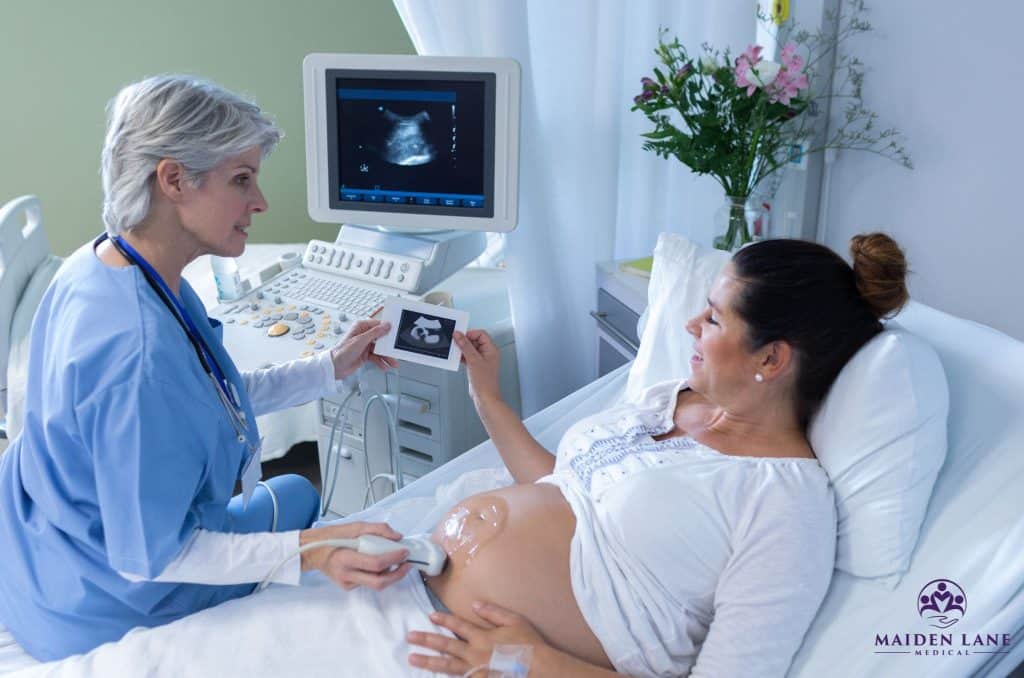 AN OB/GYN performing an ultrasound on a high-risk pregnancy patient.