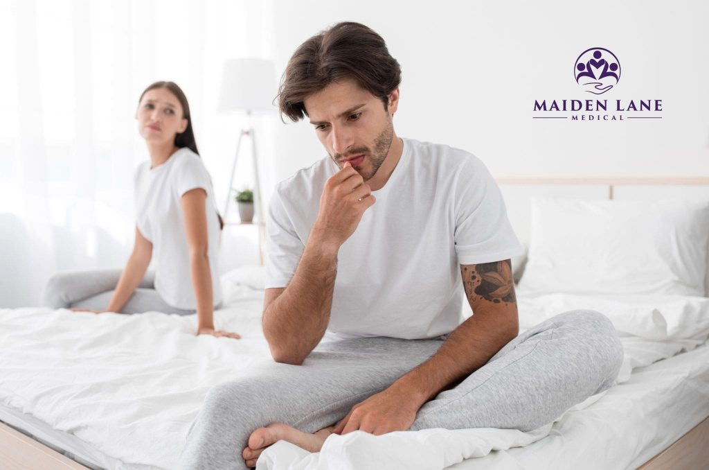 A woman and man worried about erectile dysfunction while on a bed in NYC.