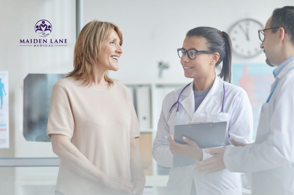A female patient in Manhattan, NY discussing her successful robot-assisted surgery with doctors.