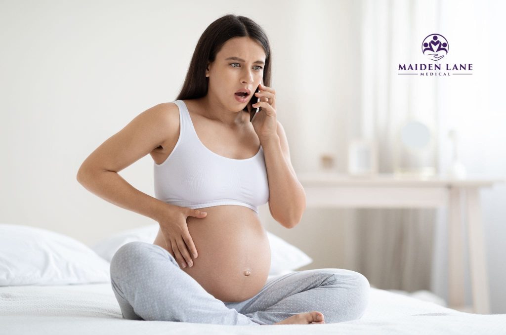 A pregnant woman feeling discomfort from Braxton Hicks contractions.
