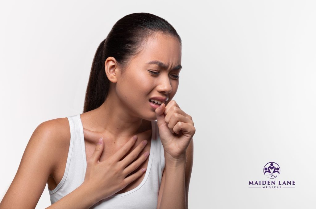 A woman coughing with bronchitis in NYC.