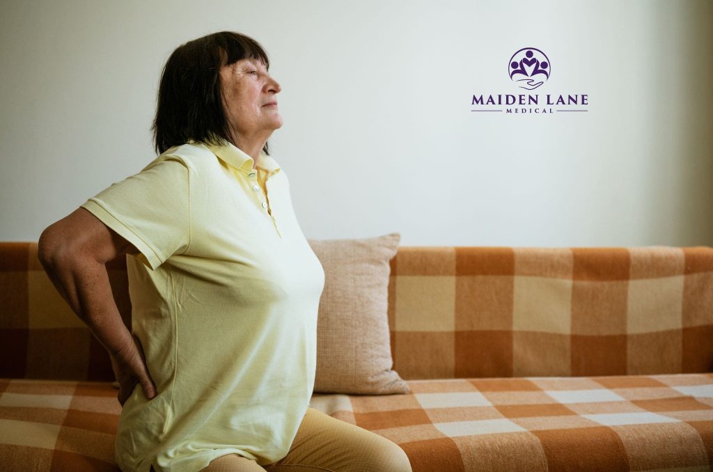 A woman with sciatica pain needing to visit a herniated disc specialist in NYC.