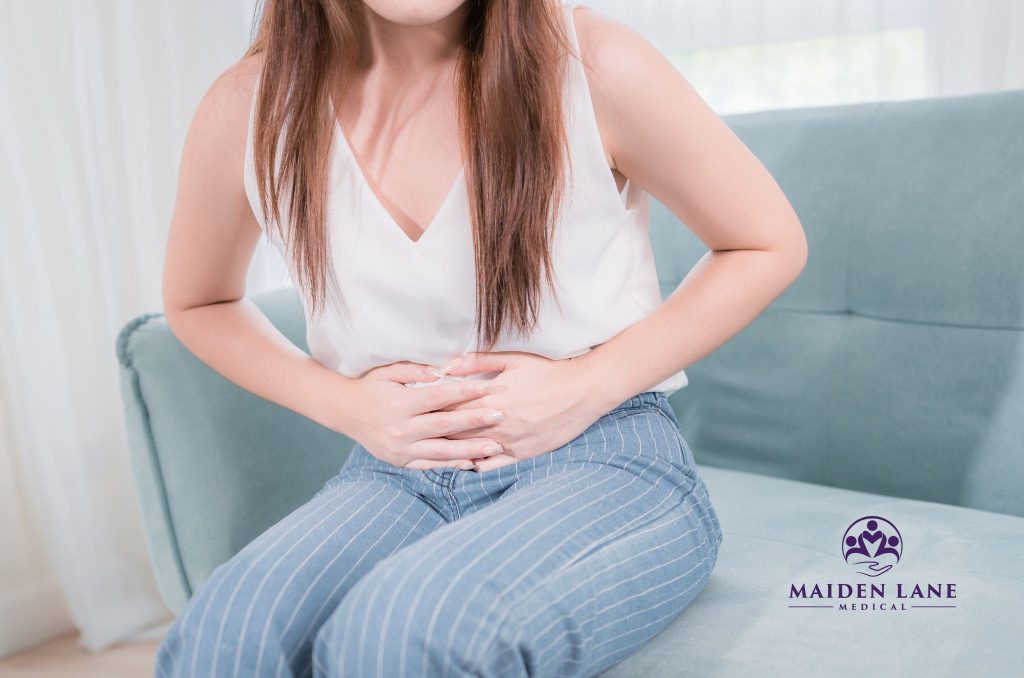 A woman experiencing pain from abnormal periods and bleeding.