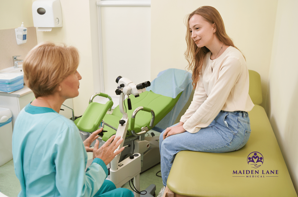 A gynecologist explaining the colposcopy procedure with a patient.